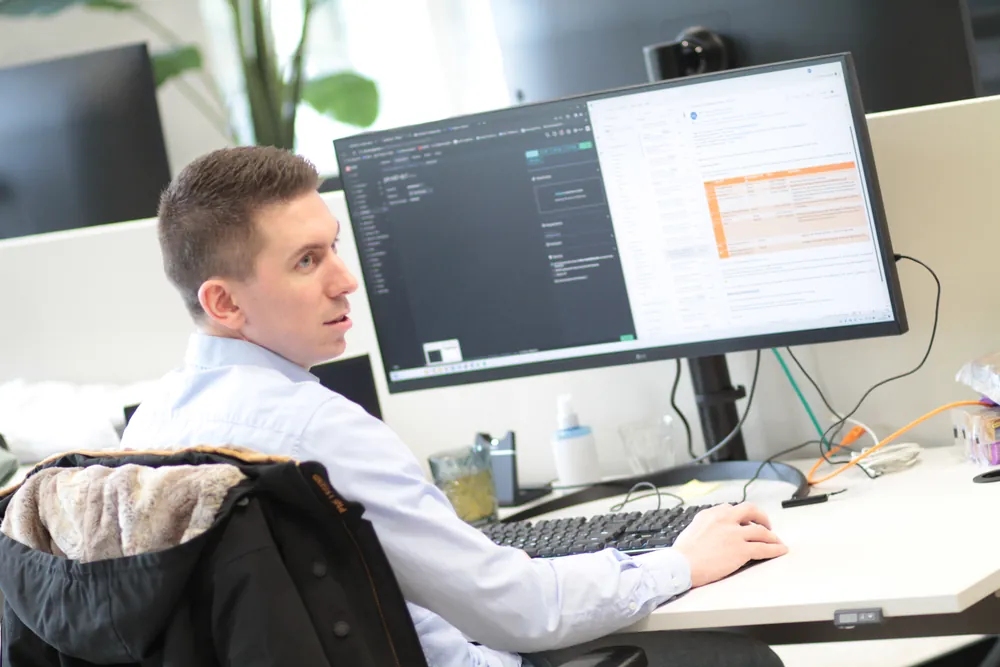DACON-medewerker aan het werk achter een breed scherm