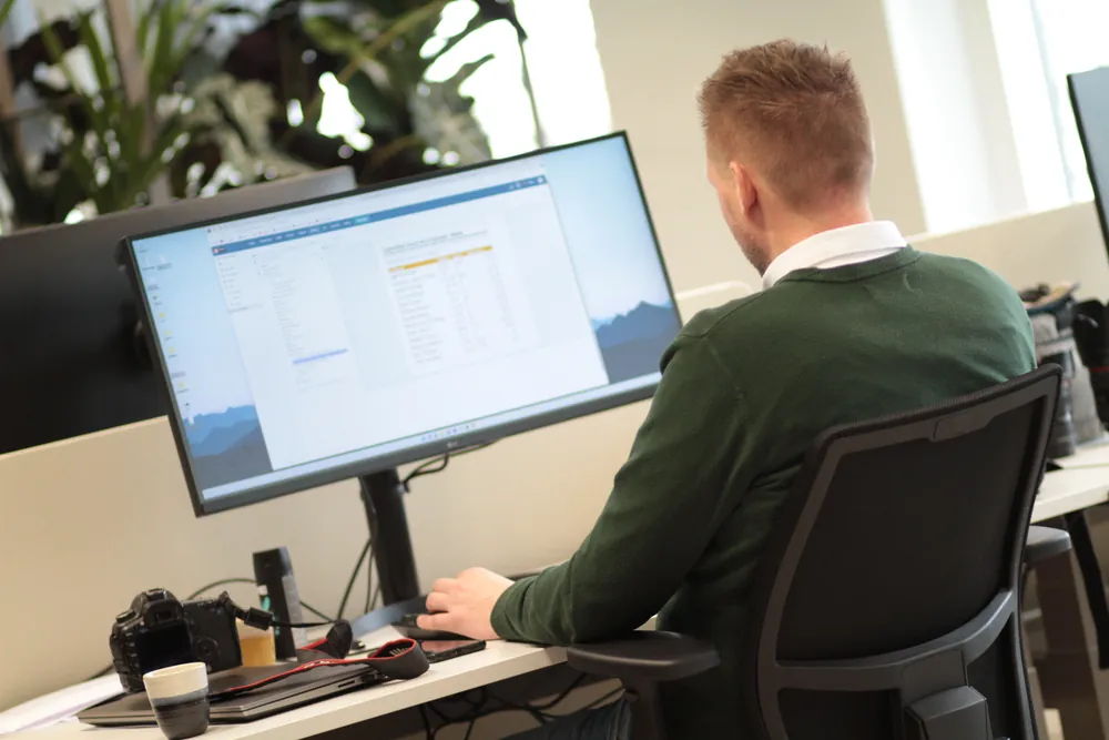 DACON-medewerker beheert systemen achter een breed scherm